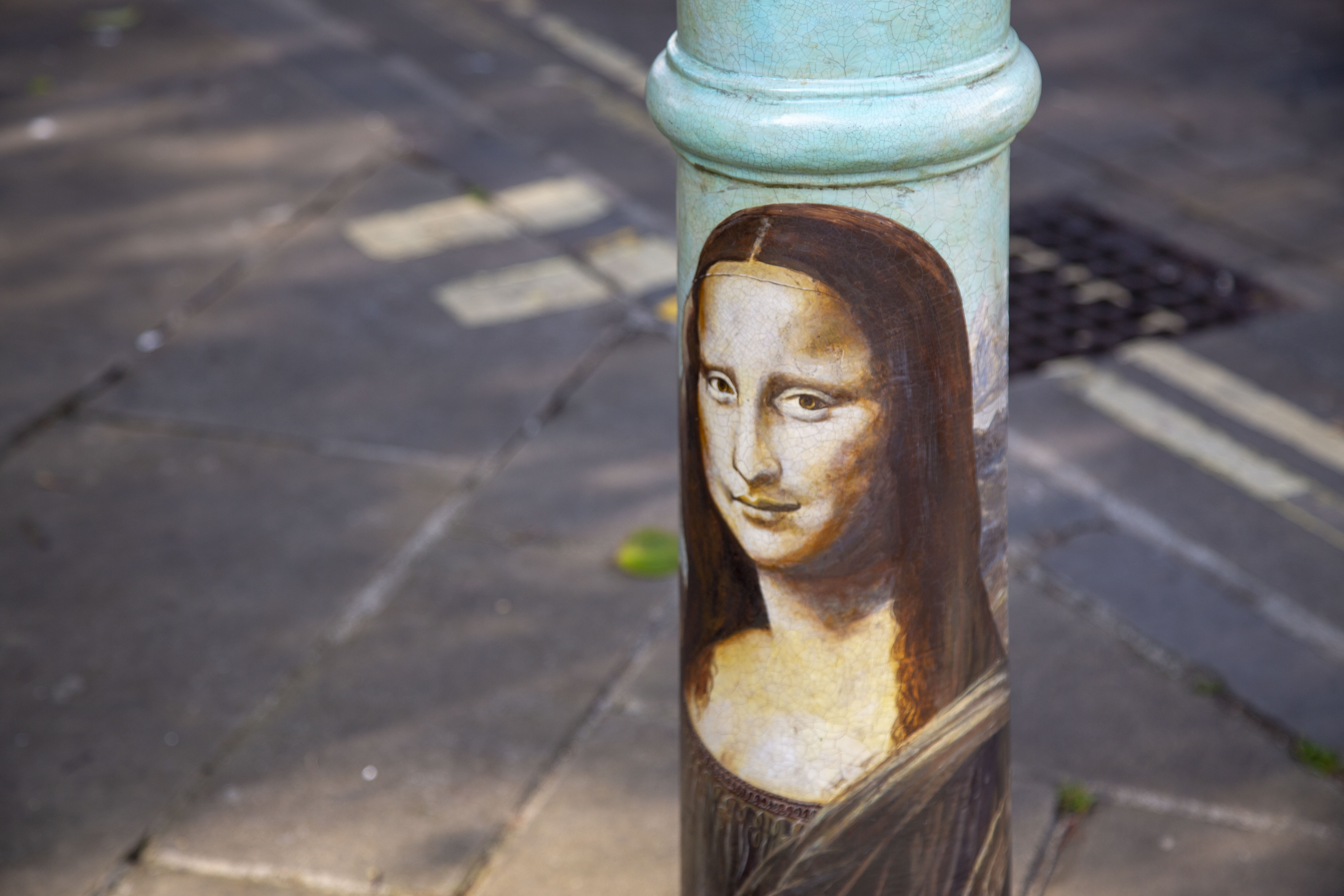 A bollard painted in the style of Da Vinci's 'The Mona Lisa'