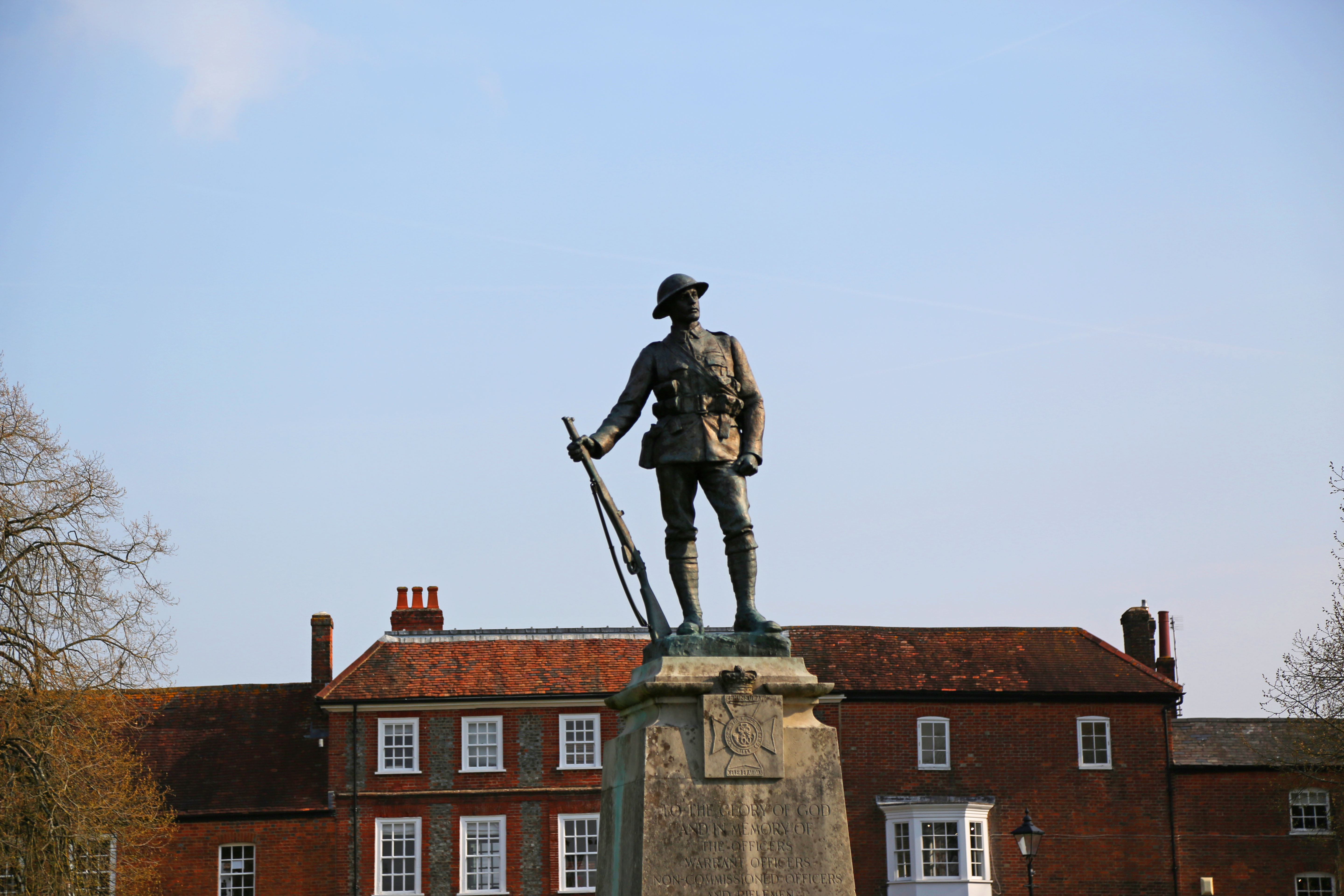 A statue commemorating soldiers from WW1 and WW2 against a blue sky