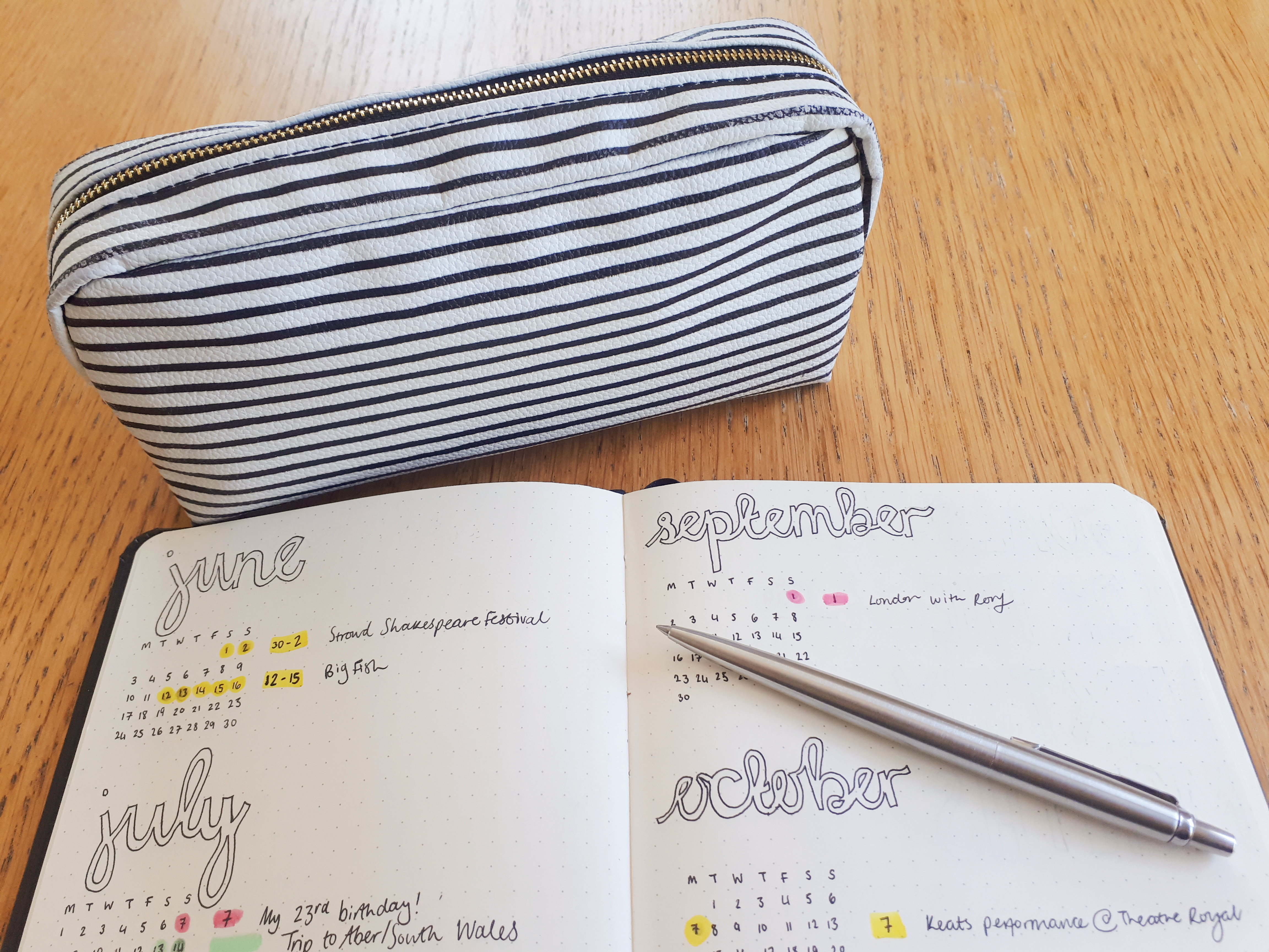 Nautical striped pencil case with a shot of Rosie's bullet journal, and silver Parker pPen