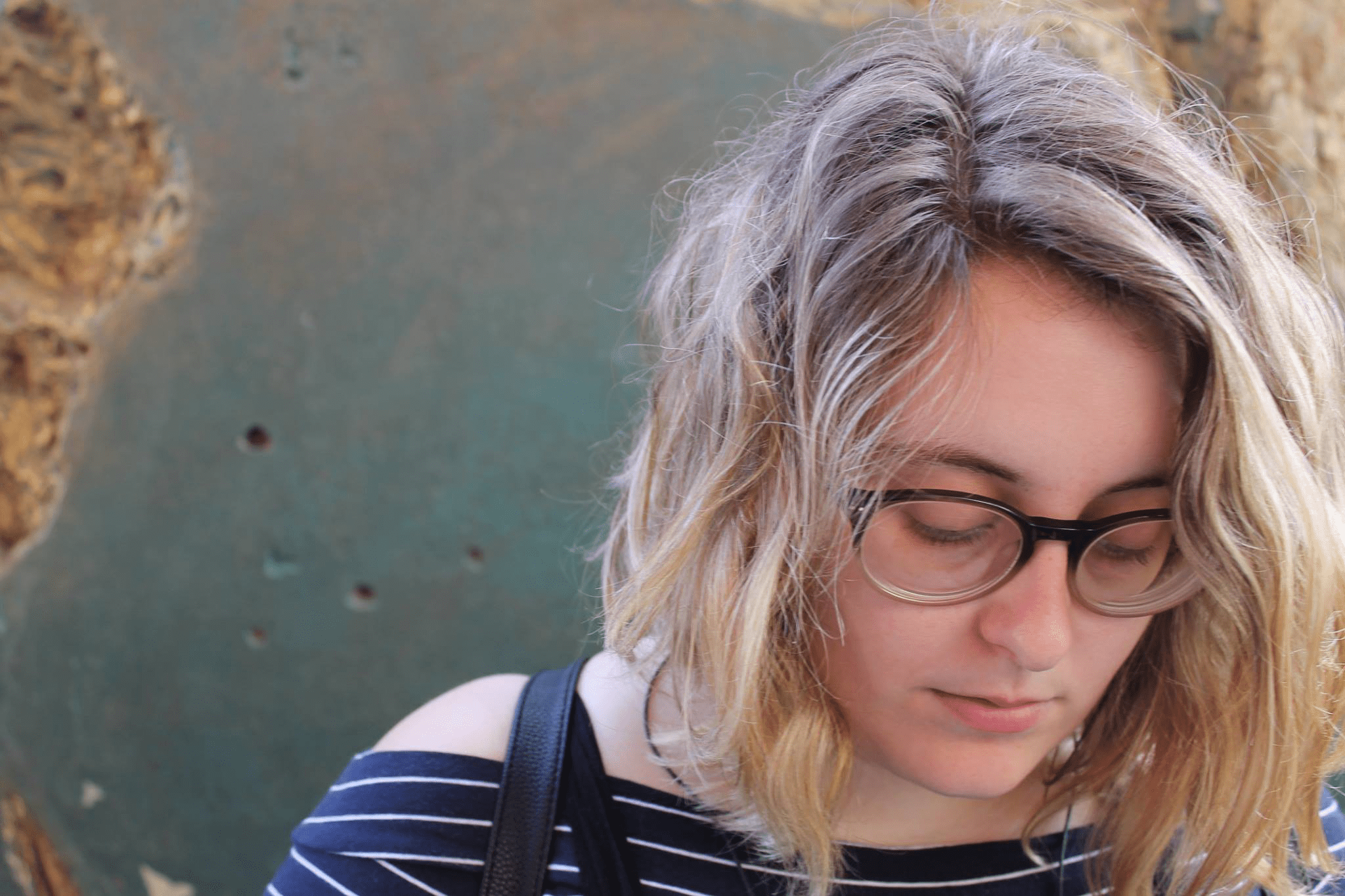 Rosie looking down, against a grey-green background