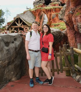 Rosie and her partner Rory stood in front of Splash Mountain ride. Rosie is wearing a read tea dress from ASOS