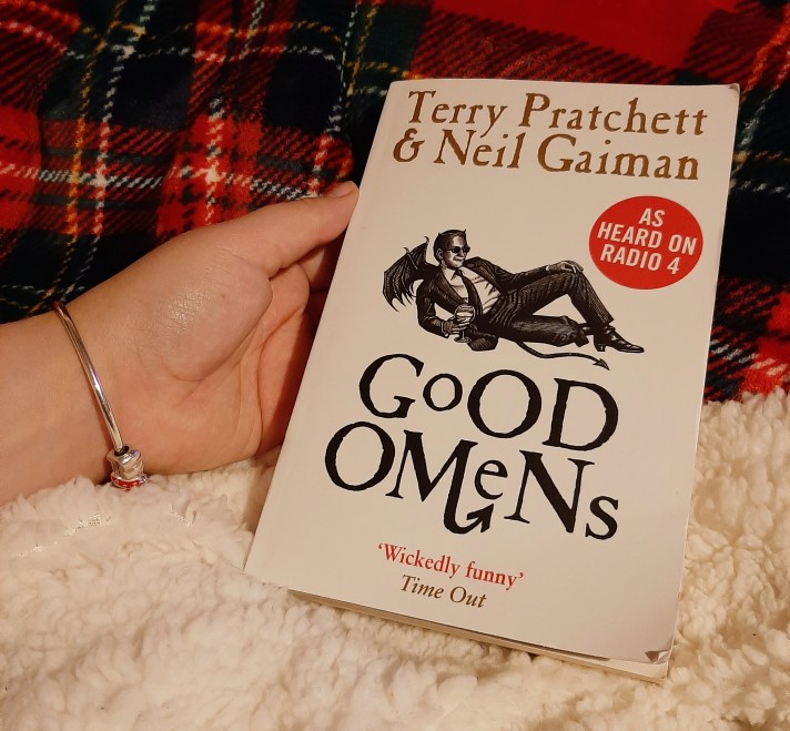 Pratchett and Gaiman's novel 'Good omens' against a checkered red blanket backdrop