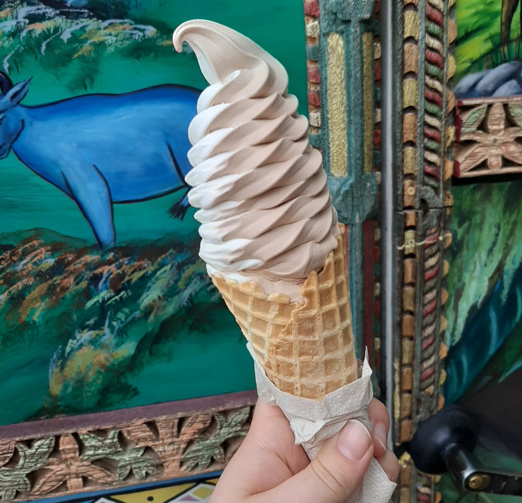 White and light brown chocolate swirl ice-cream against a blue and green background