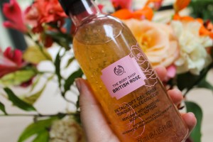 Close up of Rose Petal Toner in front of bouquet of flowers