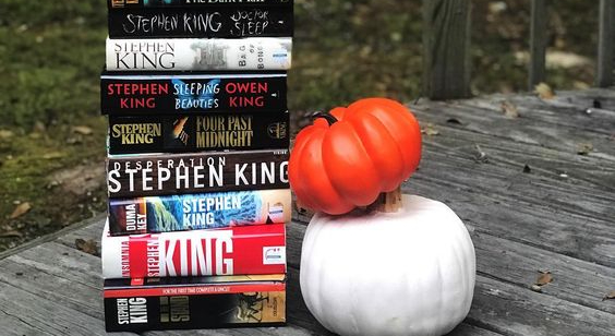 A stack of King's books, next to a pumpkin and a white gourd