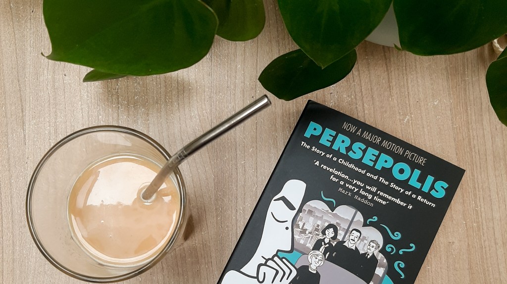 A black covered book with blue text reads 'PERSEPOLIS'. To the left is an iced coffee, above are some green leaves.