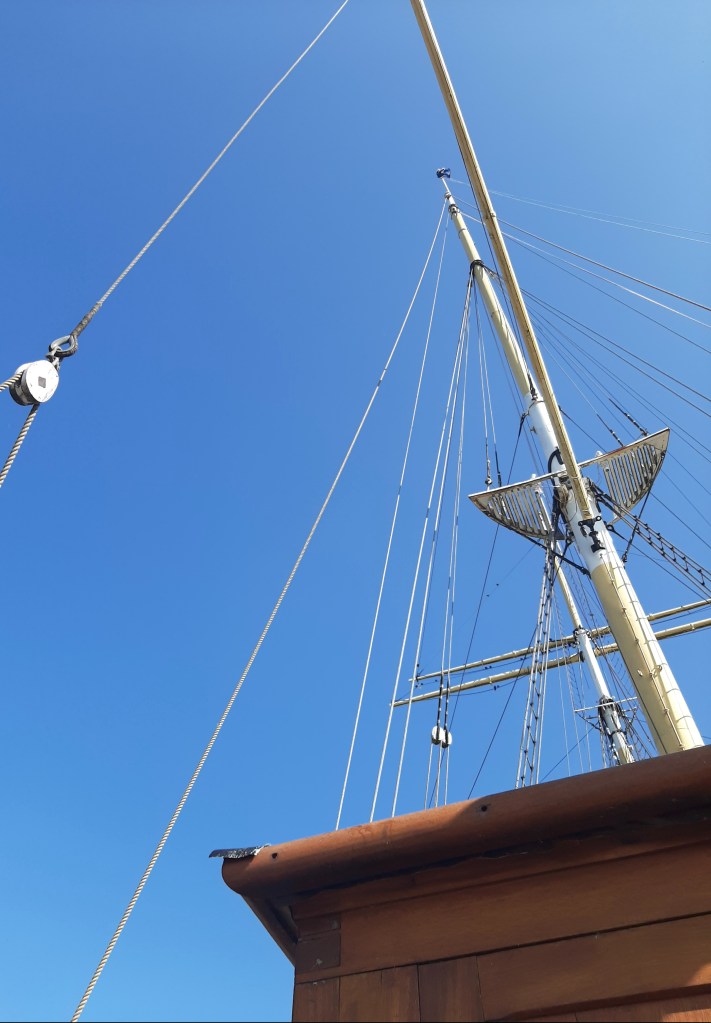The mast of the Glenlee poking through the clear blue sky