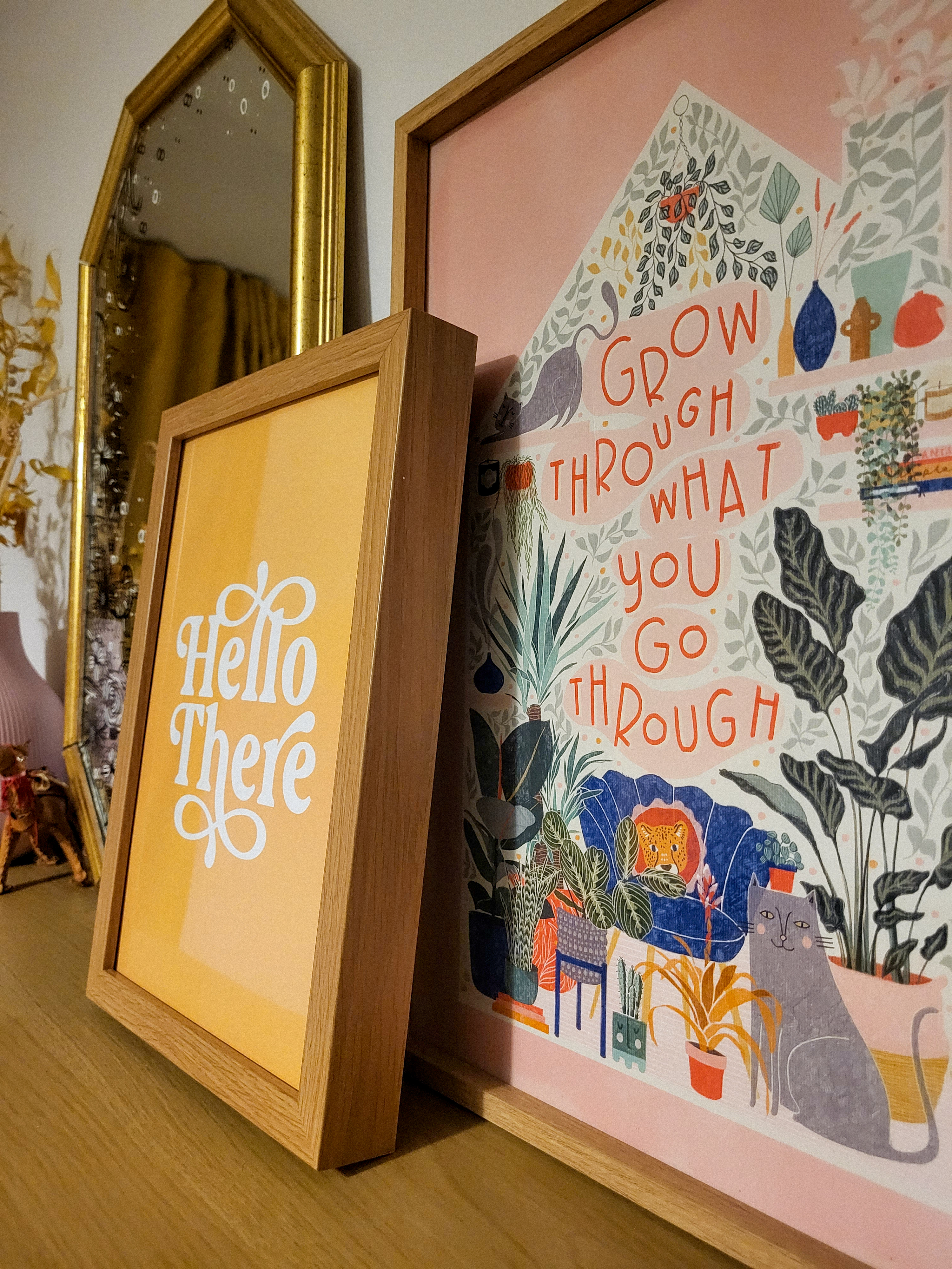 A yellow print saying 'hello there' and a pink print saying 'grow through what you go through'