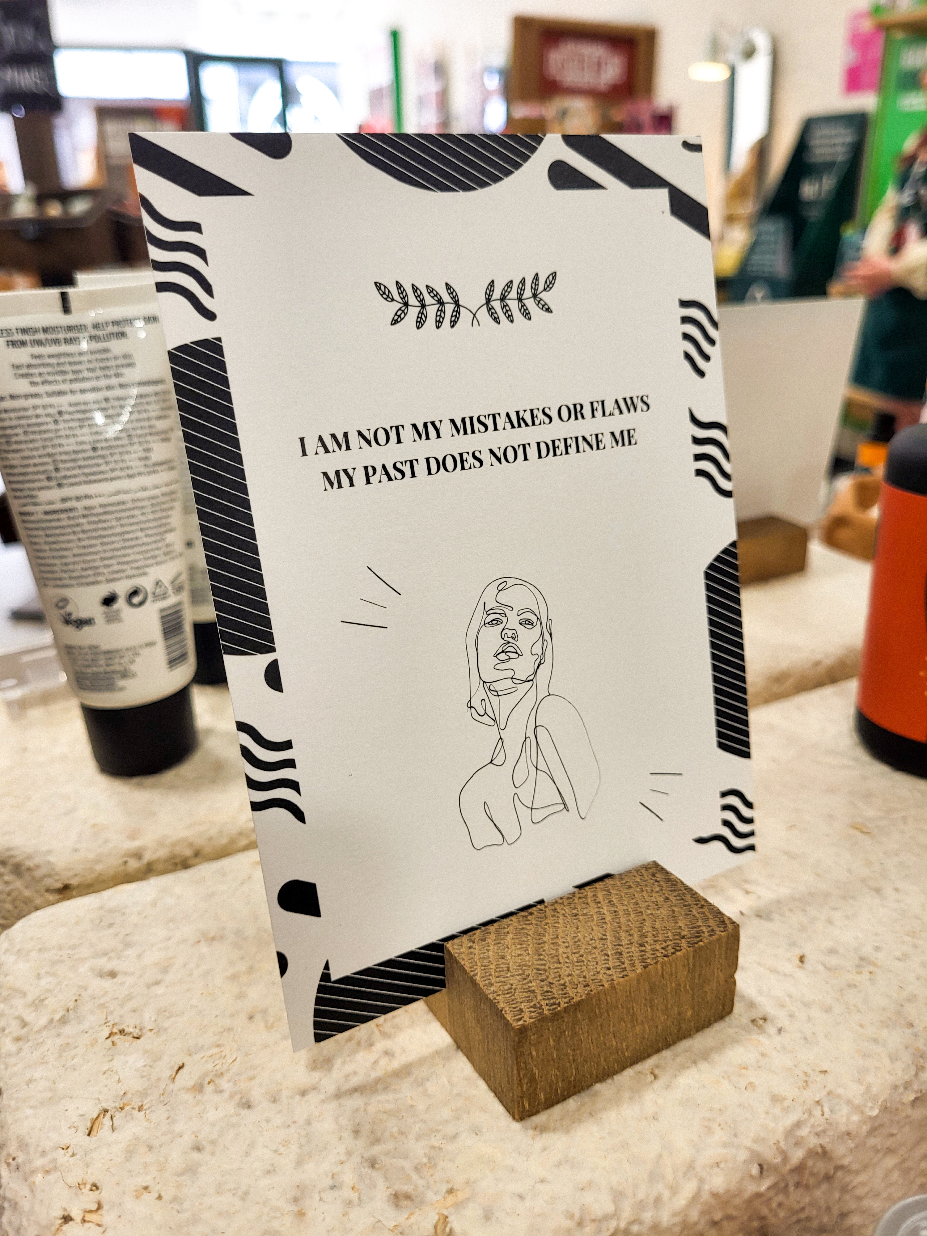 An affirmation card in black and white that says "I am not my mistakes or flaws, my past does not define me"