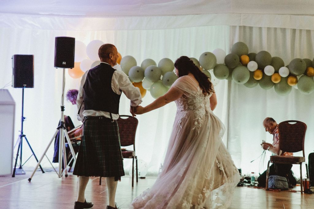 Rosie and her dad at the father-daughter dance. He is on the left about to twirl here. She is on the right and her dress is twirling. 