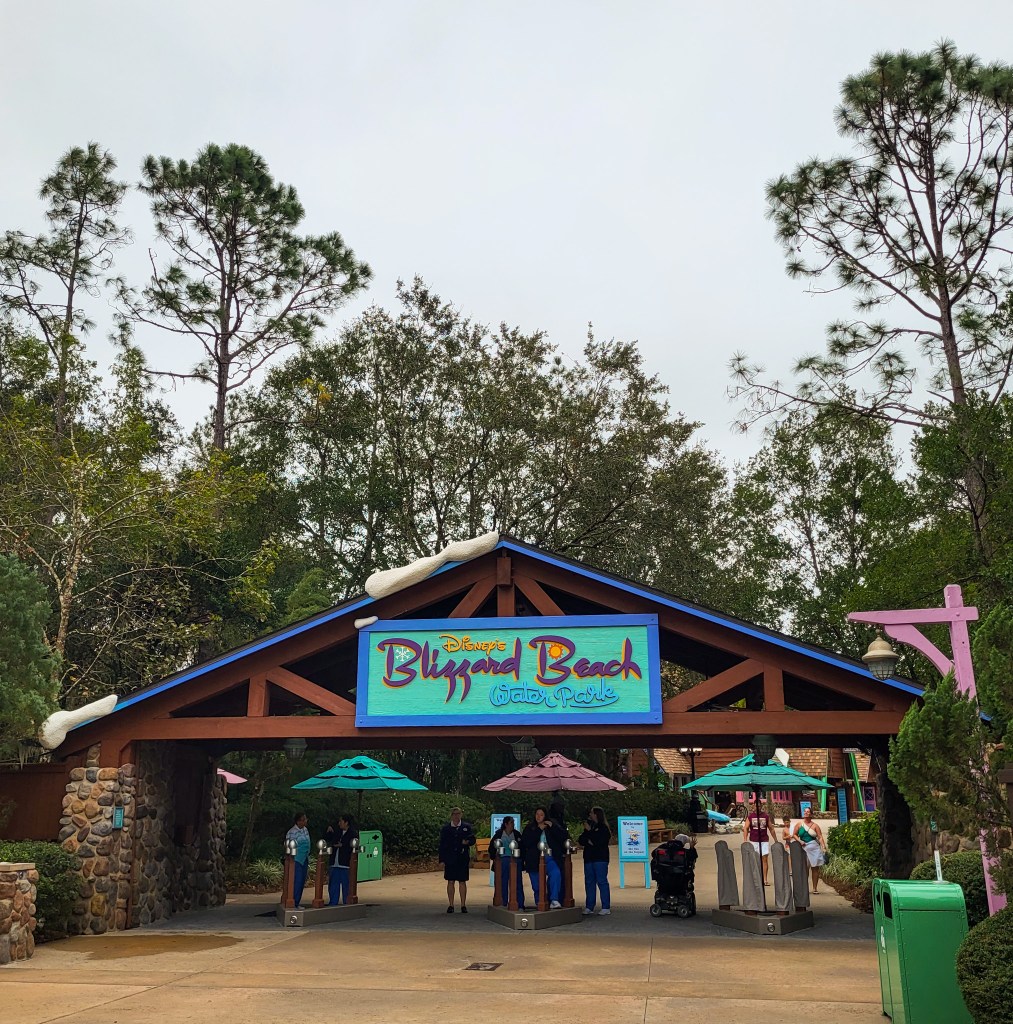 An image of the dark wooden entrance to Blizzard Beach, with a blue sign reading 'Blizzard Beach Water Park'